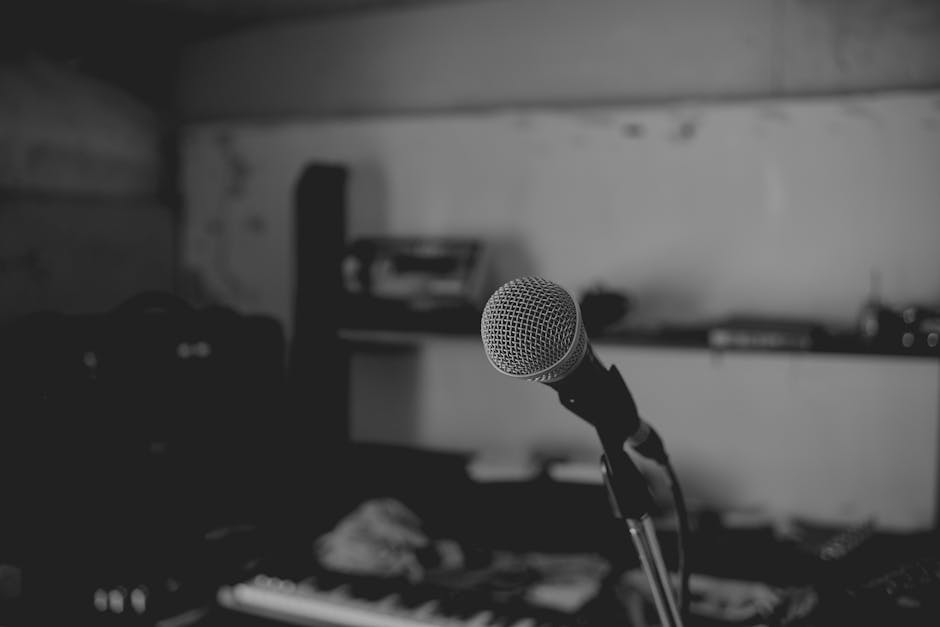 Artistic black and white shot of a music studio with a focus on a microphone. Perfect for music-themed projects.